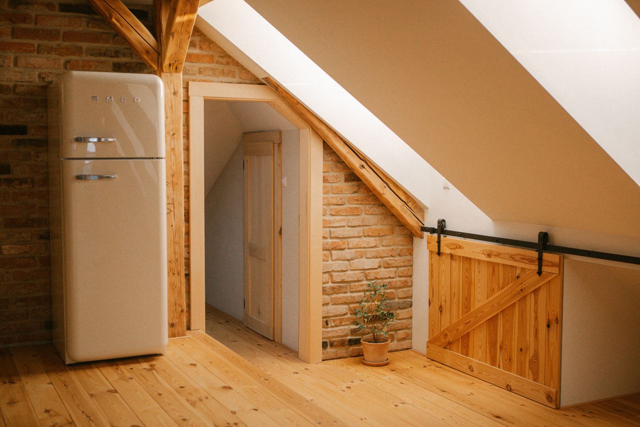 Converted attic with retro fridge and barn door. 