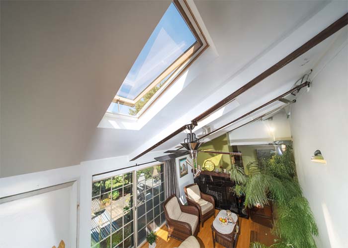 Bright sunlight entering through a roof skylight into a cozy living room