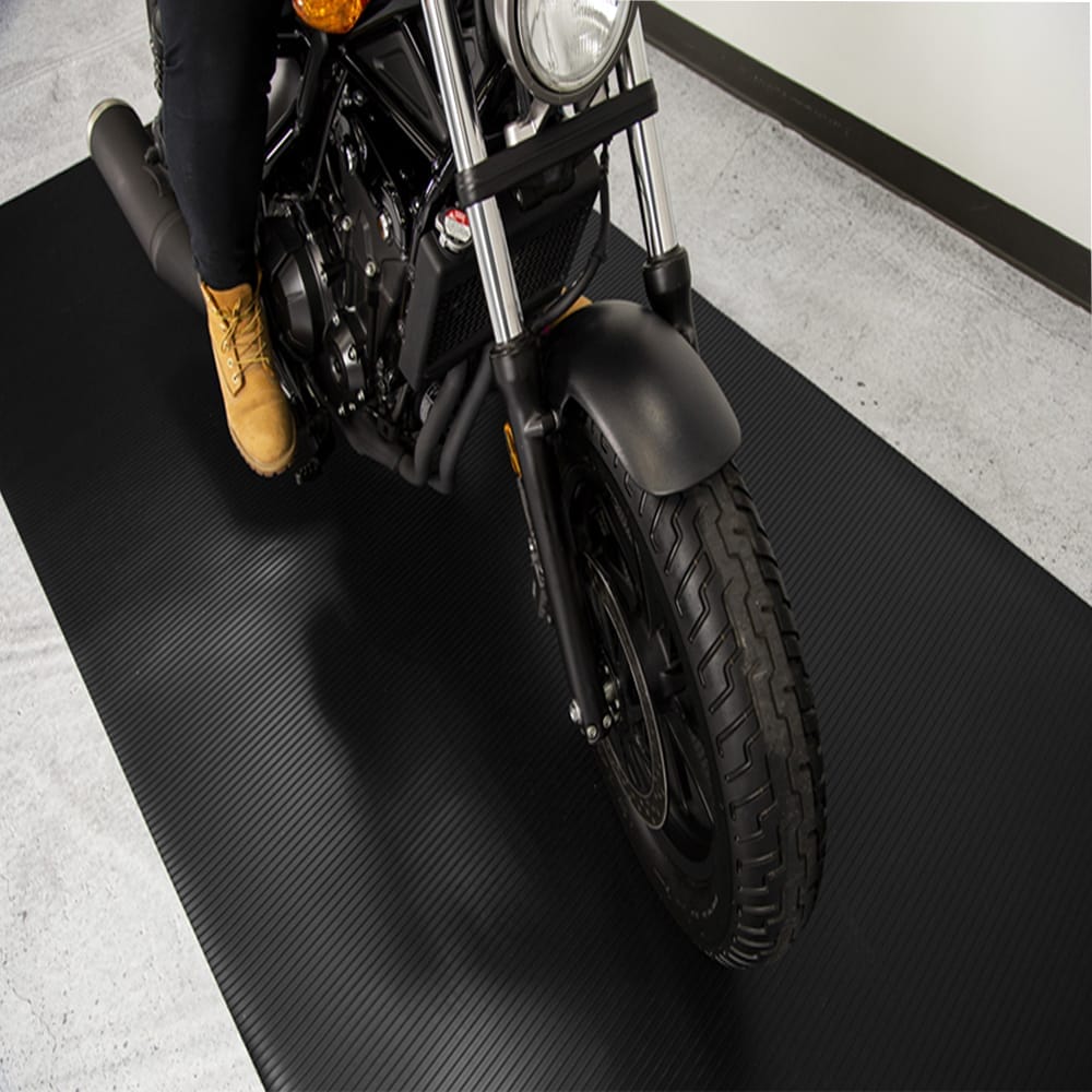 A Man Sitting On A Motorcycle Positioned On A Black Ribbed Motorcycle G-Floor Mat