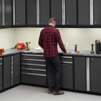 A Man Stands At A Corner Workstation Surrounded By Sleek Black Cabinets And Tools Neatly Arranged On A Stainless Steel Countertop