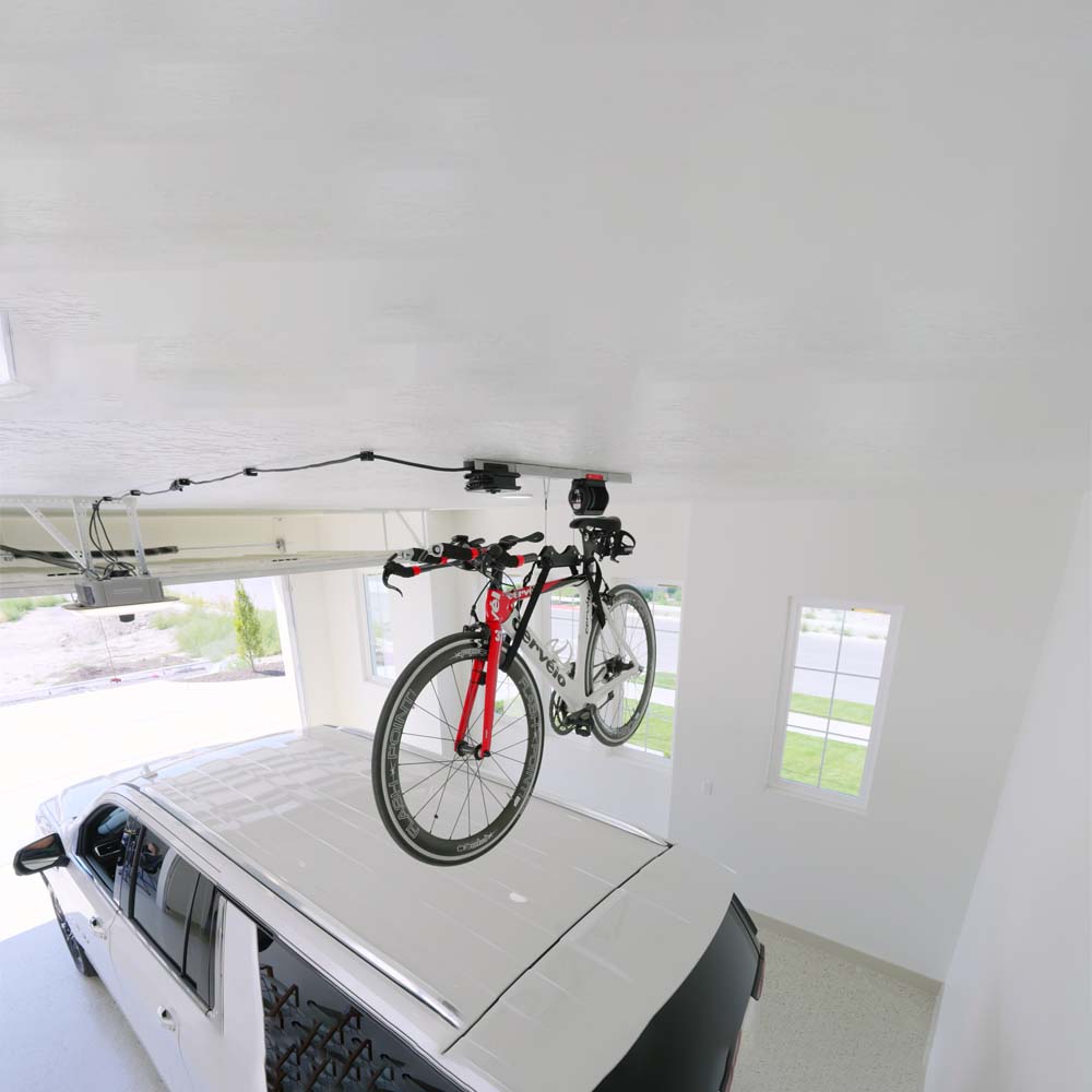 A Red And Black Road Bike Is Suspended Above An Off Road Vehicle By SmarterHome Garage Smart Bike Lift