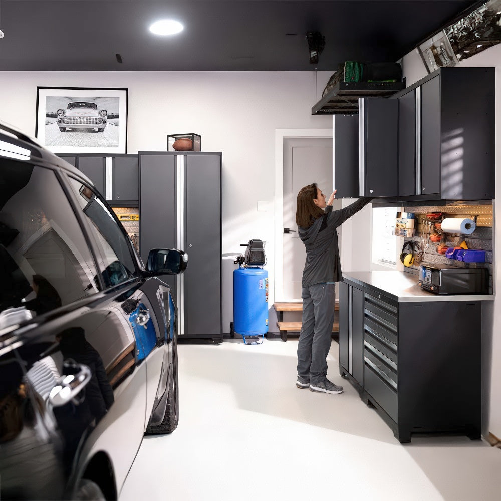 A Woman Reaches Into A Sleek Upper Cabinet In A Modern Well-Organized Garage With A Parked SUV