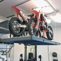 AuxxLift Motorized Garage Storage Lift Installed In A Garage Elevating Two Dirt Bikes For Space Efficient Storage