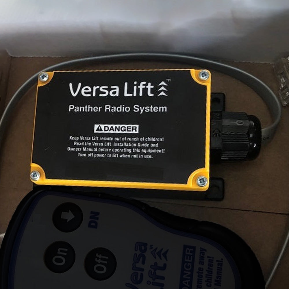 Black And Yellow Versa Lift Panther Radio System Control Box With Warning Labels And A Connected Remote