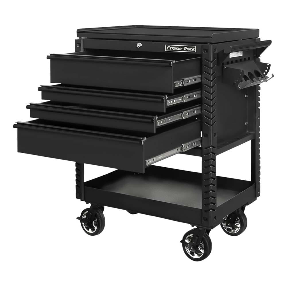 Black Extreme Tools Tool Chest Trolley With Three Open Drawers, A Side Tool Holder, A Handle On The Side And A Lower Shelf All Mounted On Large Casters