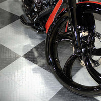 Black Front Wheel And Suspension Of A Motorcycle Set Against A Checkered Racedeck Tiles