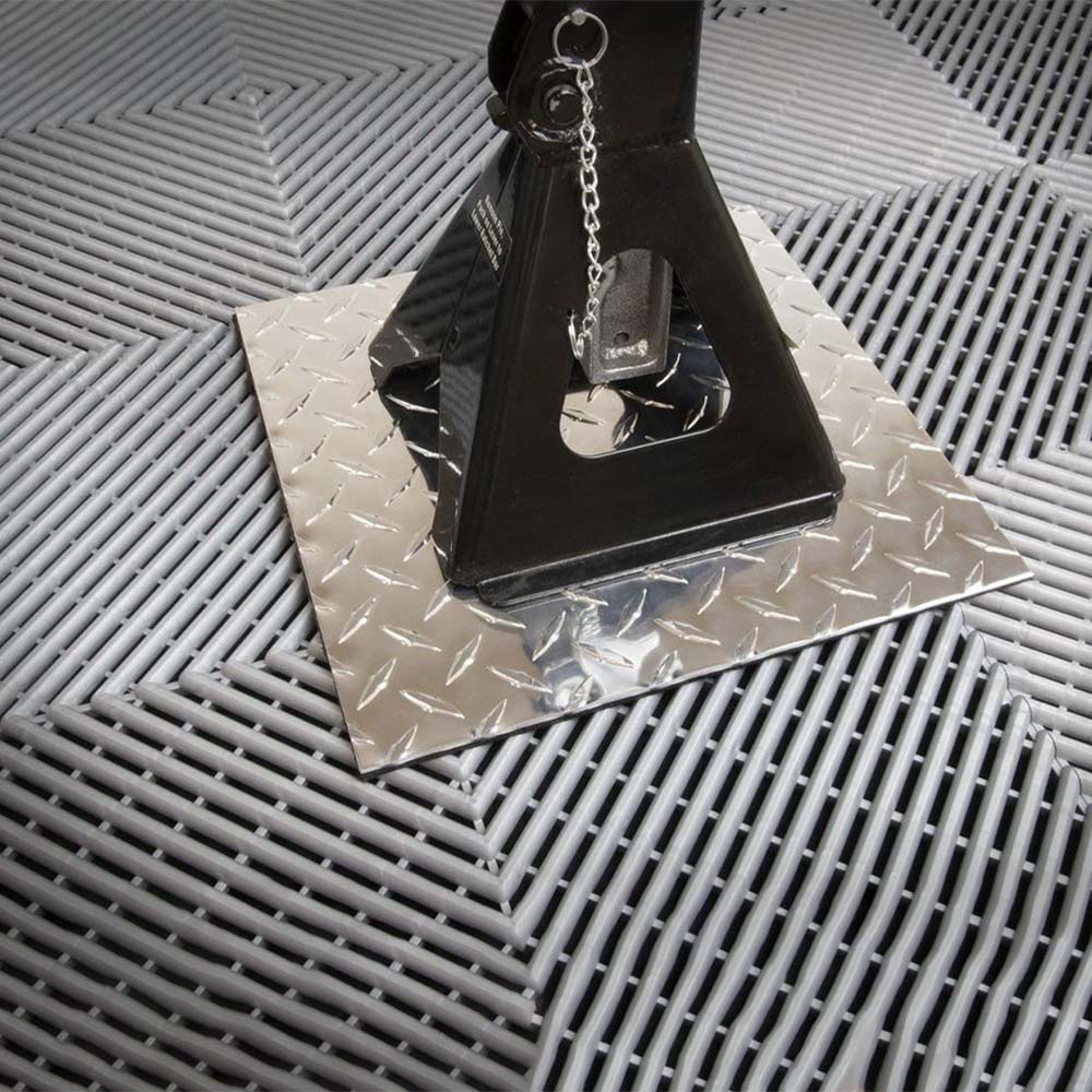 Black Metal Racedeck Tiles Jack Plate With A Chain Attached Placed On A Diamond Patterned Metal Plate
