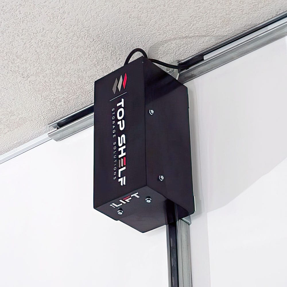 Black Motorized Unit Labeled Top Shelf Lift Attached To A Top Shelf Storage Solutions On A Textured Ceiling