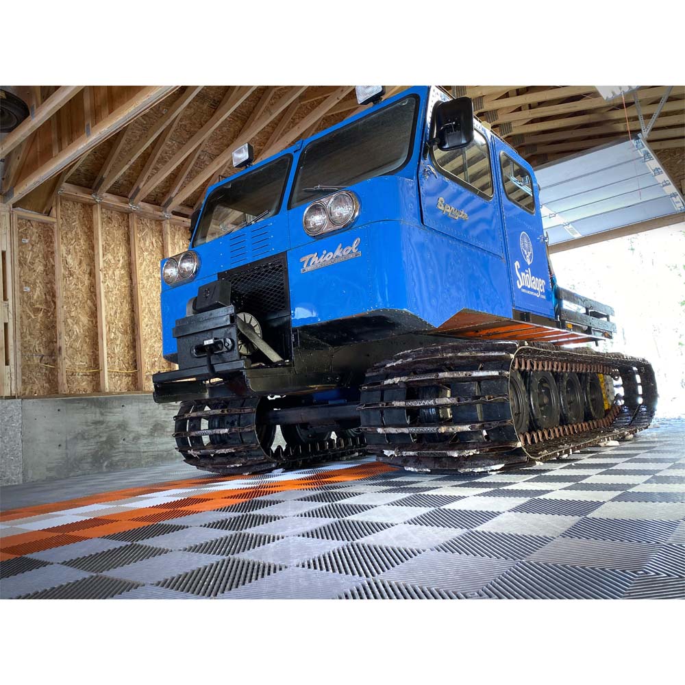 Blue Tracked Vehicle Parked In A Workshop With A Wooden Roof Structure And A Distinctive Checkered Racedeck Flooring