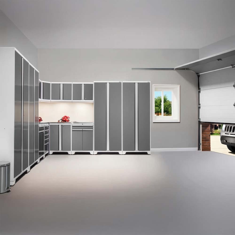 Bright Garage With L Shaped Gray Cabinetry White Trim Open Garage Door And Spacious Epoxy Floor