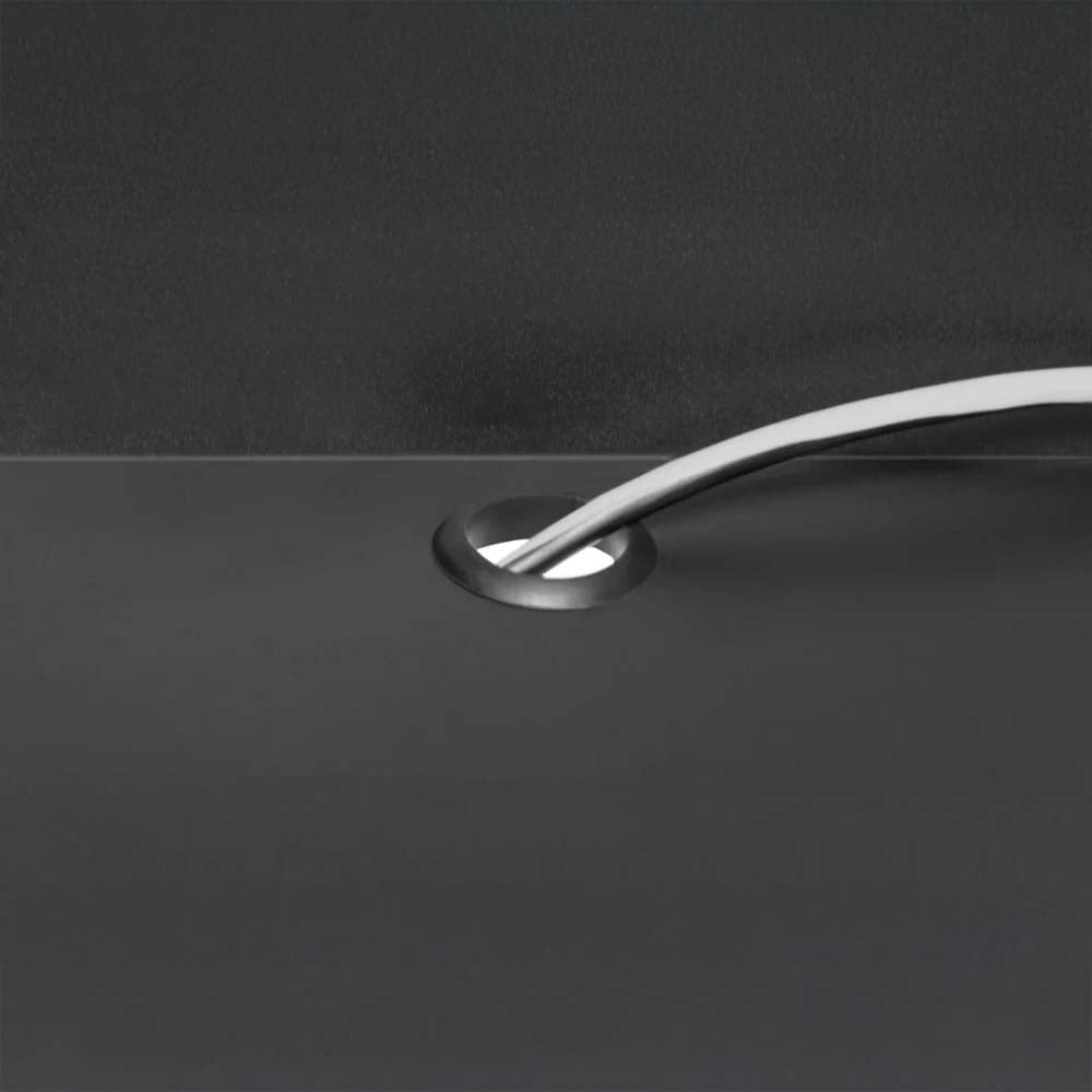 Close-Up Of A Cable Management Grommet In A Black Surface With Two White Electrical Cords Neatly Routed Through It