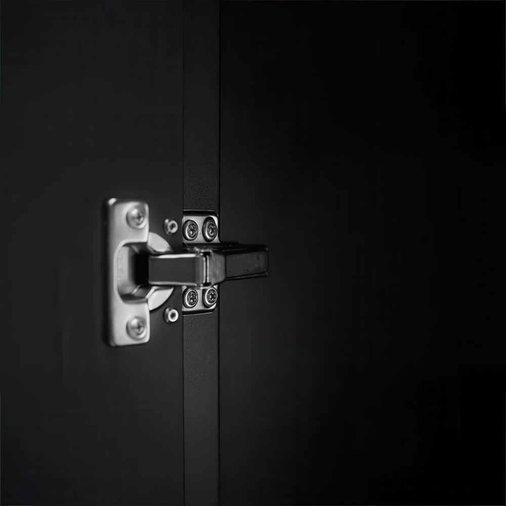 Close-Up Of A Metal Cabinet Hinge On A Black Door With Visible Screws