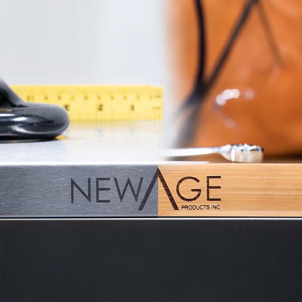 Close-Up Of A NewAge Products Inc. Logo Printed On The Edge Of A Work Surface That Combine Brushed Metal And Wood Finishes