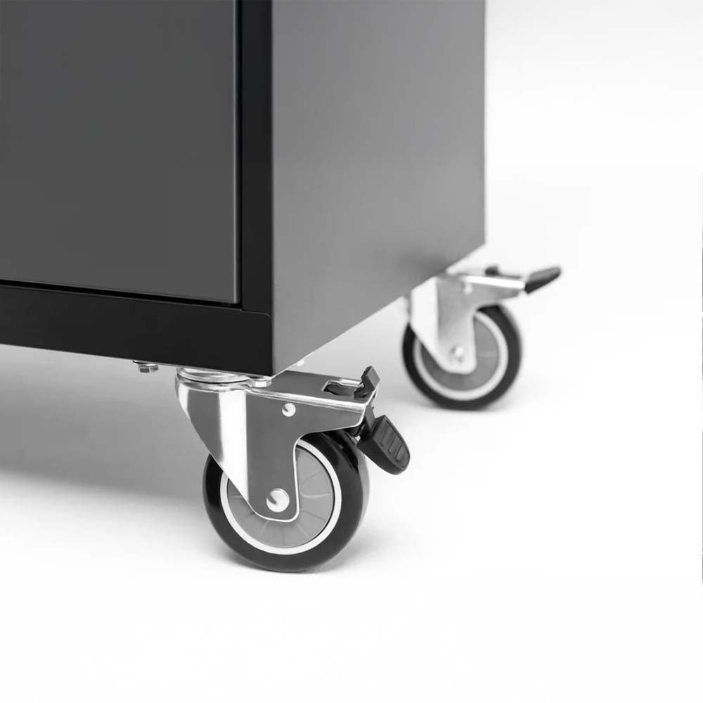 Close-Up Of Two Heavy-Duty Swivel Caster Wheels With Locking Mechanisms Attached To The Bottom Corner Of A Black Metal Cabinet