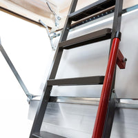 Close-Up View Of A Metal Attic Ladder With Black Steps A Red Handrail And Sturdy Metal Hinges Connected To A White Ceiling Panel