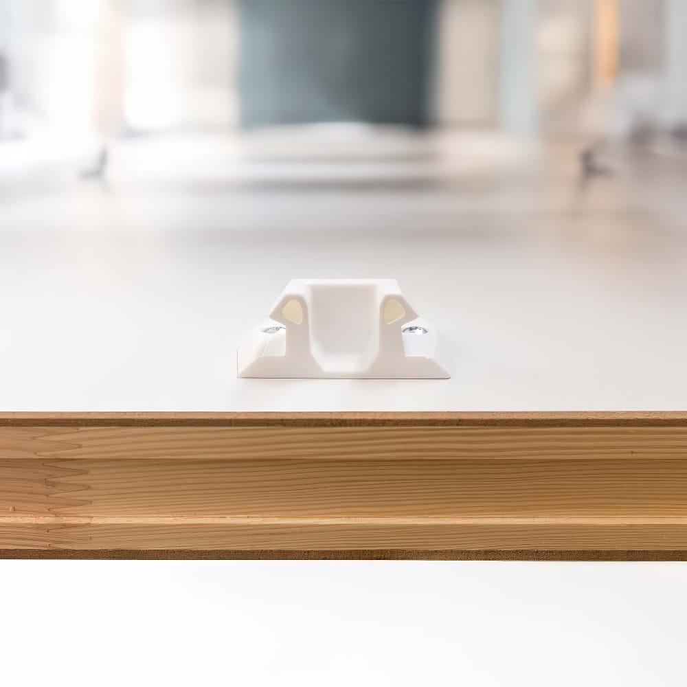Close-Up View Of A White Plastic Latch Mechanism Mounted On The Top Surface Of A Wooden Attic Ladder Door Panel