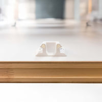 Close-Up View Of A White Plastic Latch Mechanism Mounted On The Top Surface Of A Wooden Attic Ladder Door Panel