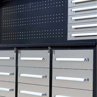 Close Up View Features A Black Pegboard Backpanel Above Silver Tool Cabinet Drawers