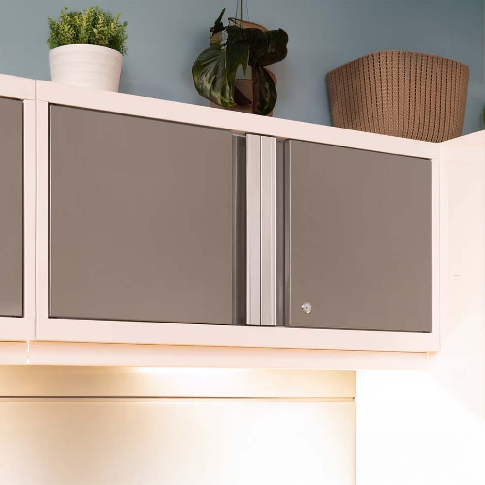 Closed Wall-Mounted Cabinet With Sleek Dark Gray Doors And A Silver Vertical Handle Topped With Decorative Potted Plants And A Woven Basket