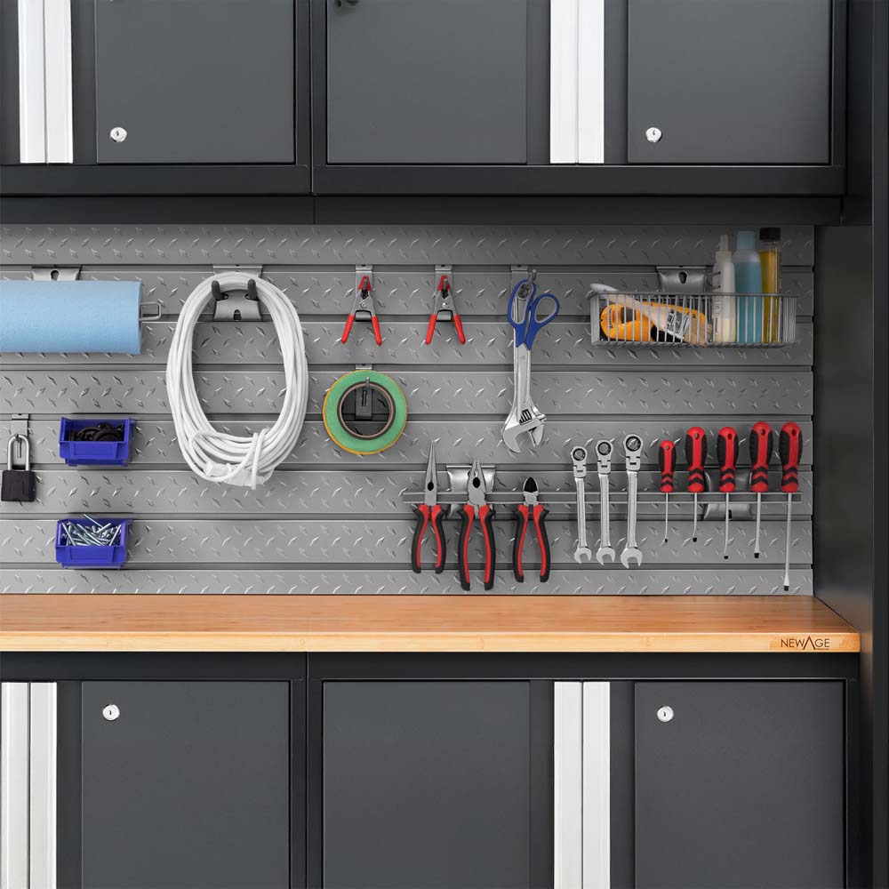 Diamond Plate Slatwall Above A Wood Worktop Displays Neatly Arranged Hand Tools Cable Paper Towels And Bins Beneath Dark Garage Cabinets