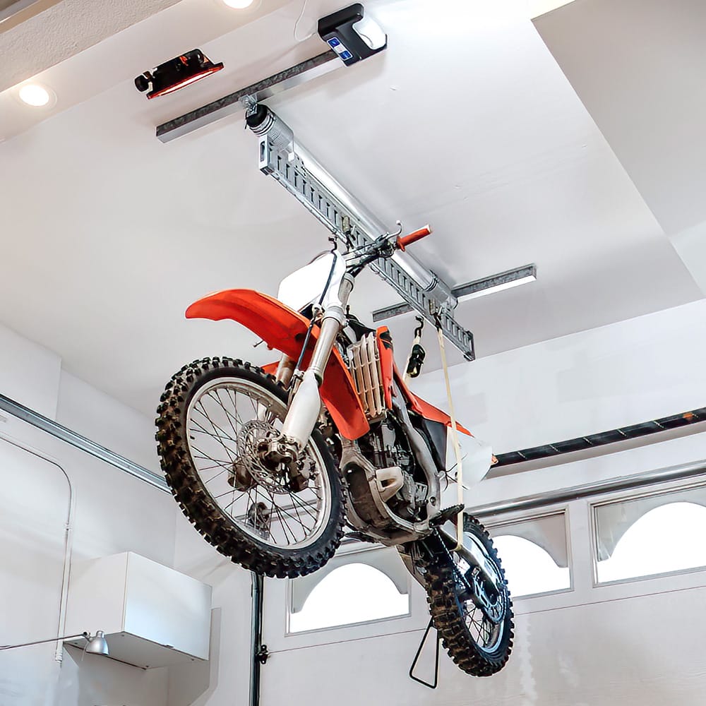 Dirt Bike Suspended From A Metal Track On The Ceiling By AuxxLift High Ceiling Bike Hoist