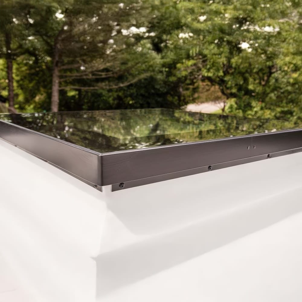 Flat Glass Roof Hatch With Black Frame Installed On White Surface Near Trees