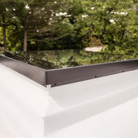 Flat Glass Roof Hatch With Black Frame Installed On White Surface Near Trees