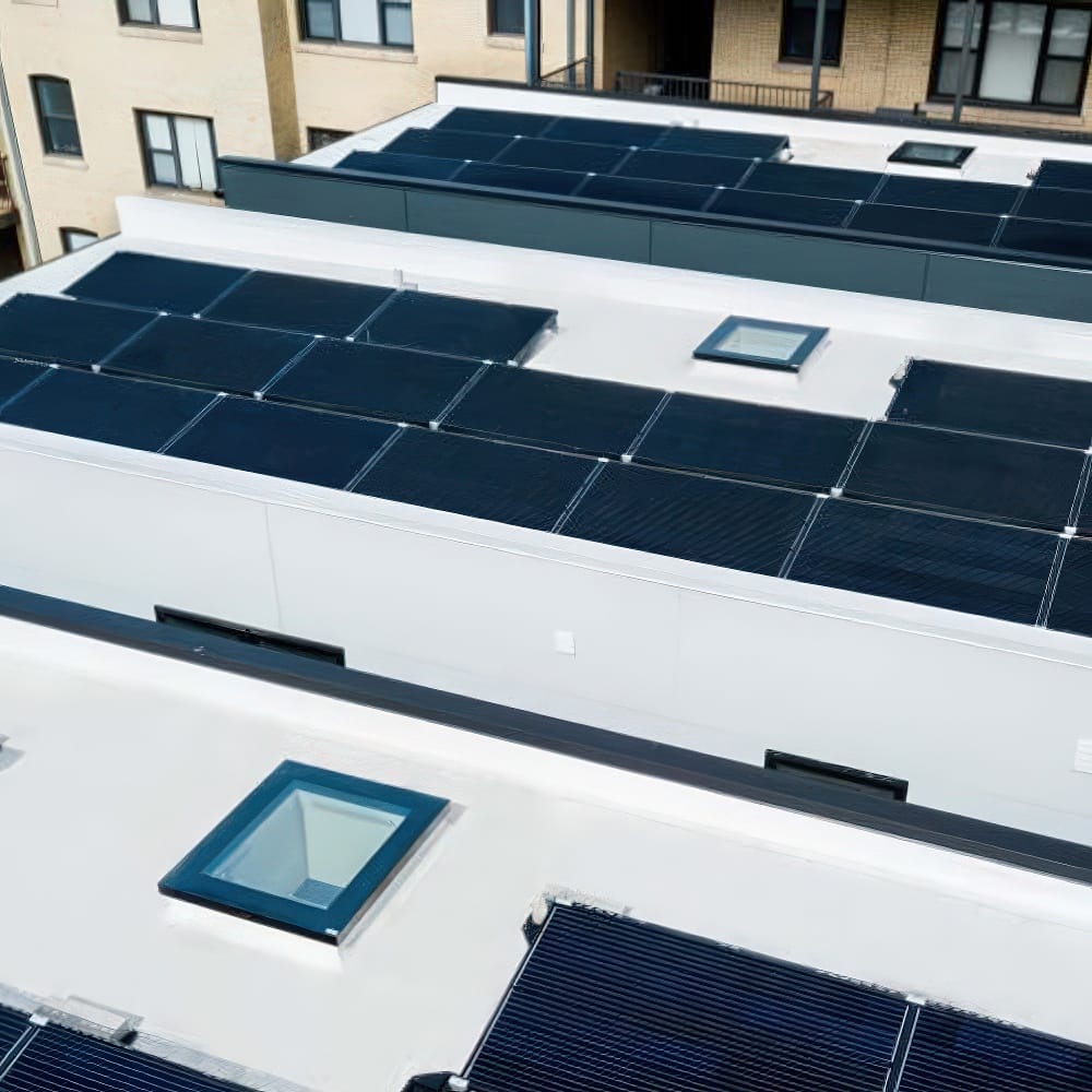Flat Rooftops With Solar Panel Arrays And Glass Skylights Near Apartment Building