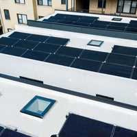 Flat Rooftops With Solar Panel Arrays And Glass Skylights Near Apartment Building