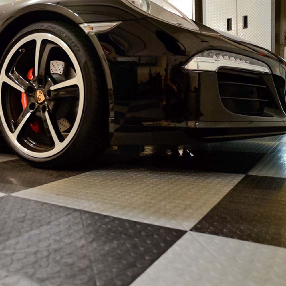 Front Portion Of A Black Sports Car Featuring Red Brake Calipers, Parked On A Race Tech Modular Flooring