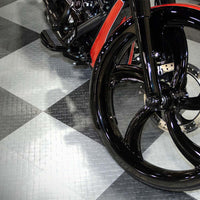 Front Wheel Of A Custom Built Motorcycle Featuring A Black Wheel And Suspension All Set Against A Checkered Racedeck Tiles