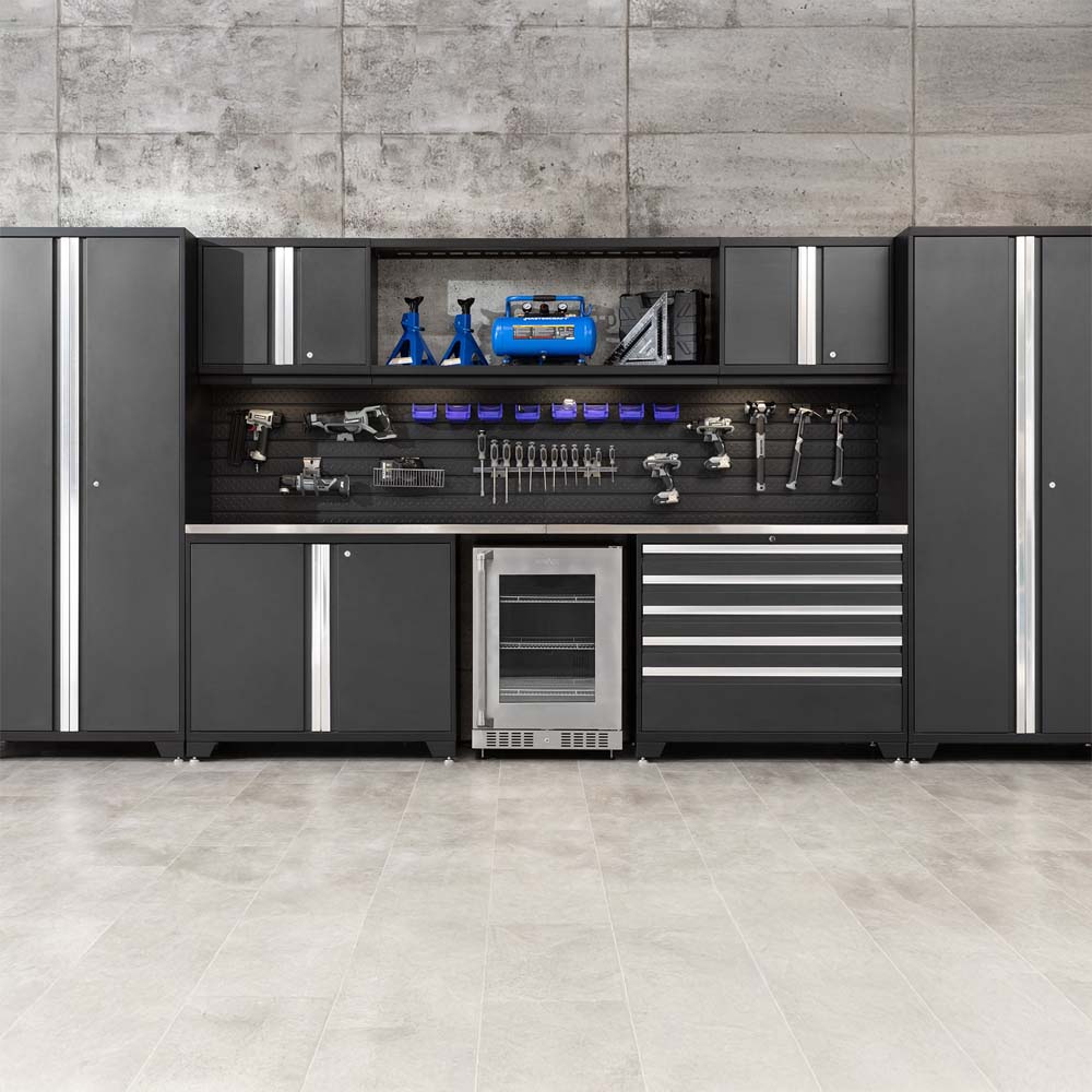Full Garage Cabinet Wall With Center Beverage Fridge And Tools Neatly Organized On Slatwall Above The Worksurface