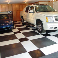 Garage With A Black And White Checkered Racedeck Garage Flooring Featuring A White SUV And A Blue Sports Car, Parked Side By Side