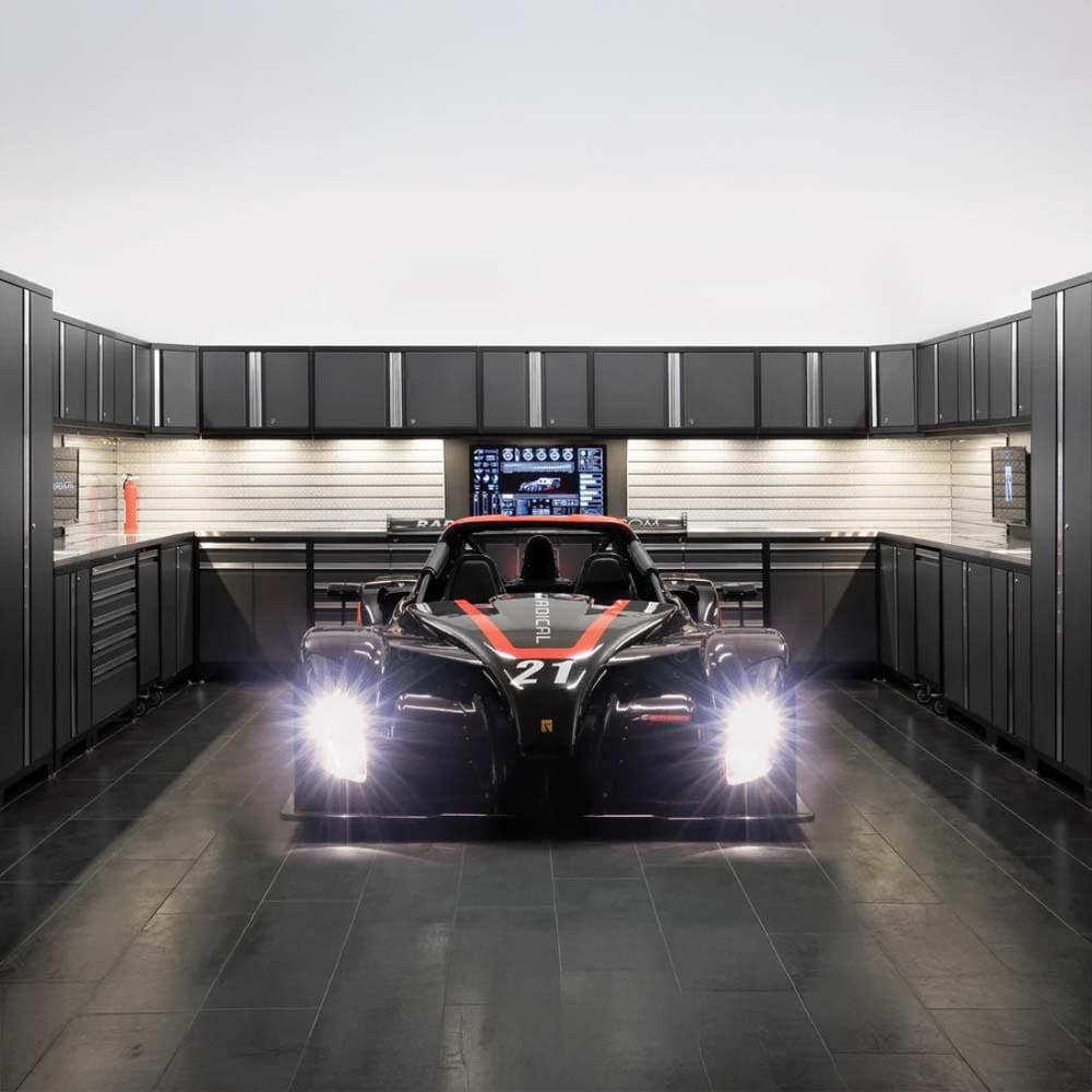 Garage With Sleek Black Cabinetry Slatwall Organization Dual Monitors And A Race Car With Headlights