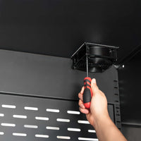 Hand Using Screwdriver To Install Fan Inside Black Metal Cabinet With Slotted Back Panel