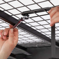 Hands Manipulating A Ratchet Wrench To Secure A NewAge 4 Ft X 8 Ft VersaRack Pro Height Adjustable Overhead Rack In Black