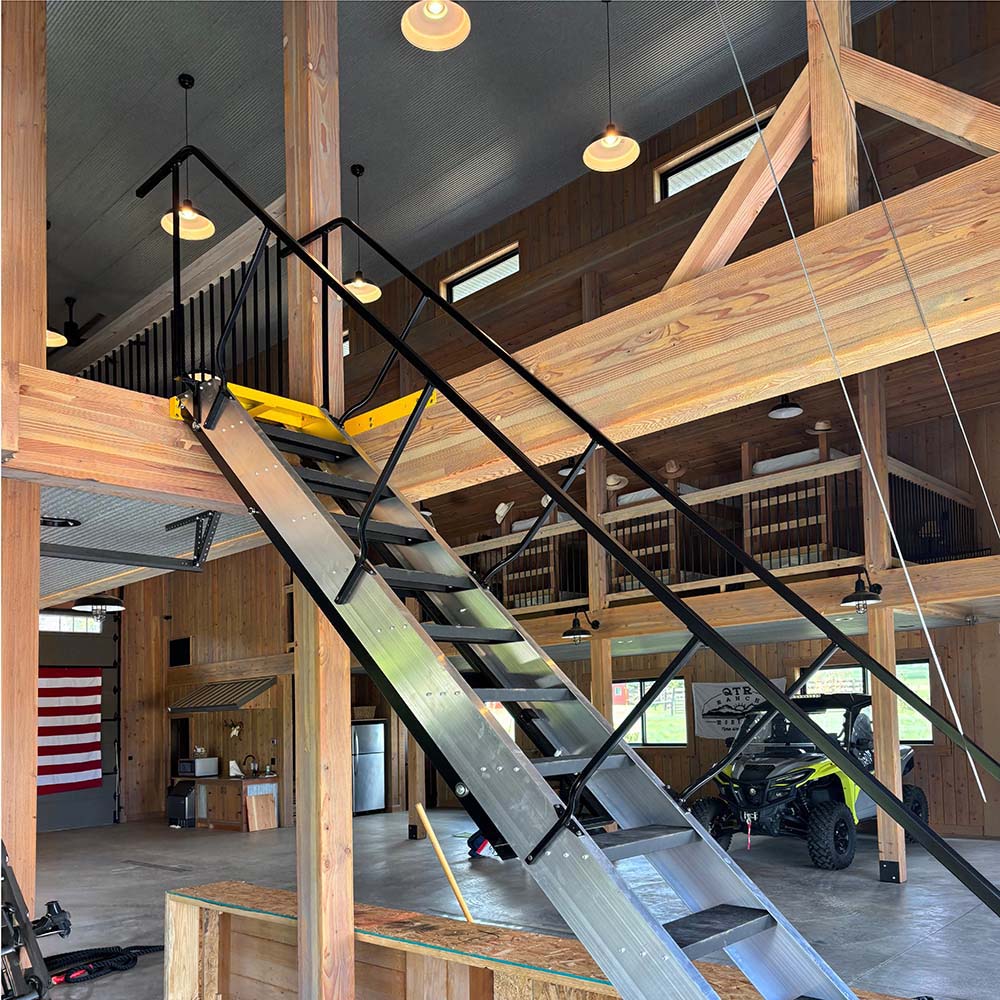 Industrial Metal Staircase Leading To A Wooden Mezzanine Inside A Spacious Post And Beam Barn Structure