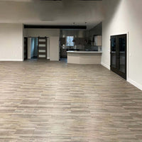 Living Area With Light Colored Wood Look Racedeck Flooring And A Modern Kitchen Featuring Dark Cabinets And Countertops