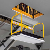 Yellow attic lift system installed in a ceiling opening of a modern garage space.