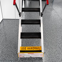 Majic Heavy Duty Attic Stairs With Black Treads And Red Handrails Featuring A Sign At The Bottom That Reads Use Handrail