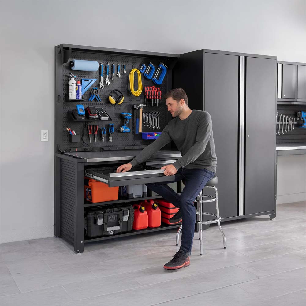 Man Sitting On Stool Opening Workbench Drawer In Modern Garage With Tools