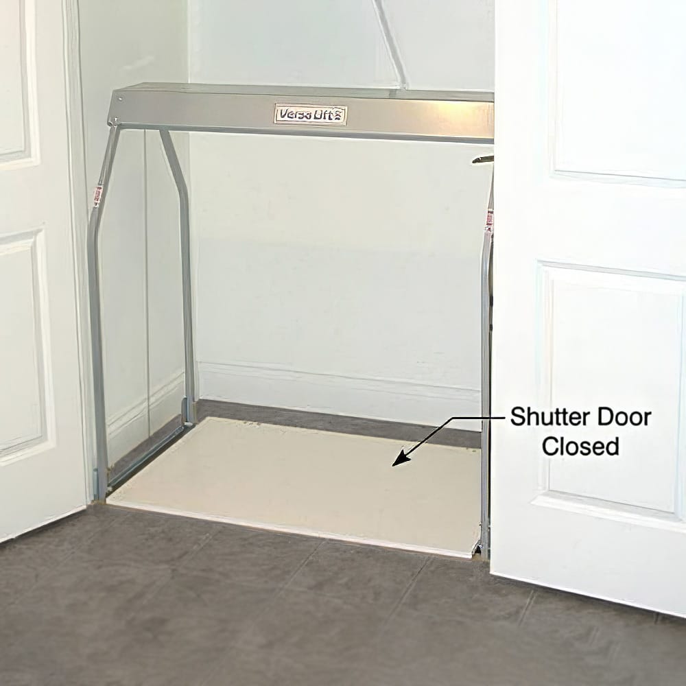 Metallic Frame Labeled Versa Lift Installed In A Doorway With An Annotation Pointing To The Bottom indicating A Close Shutter Door