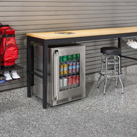Modern Garage Setup With A Long Wooden Workbench A Stainless Steel Glass-Door Beverage Fridge Stocked With Cans A Chrome Bar Stool And Organized Gear 