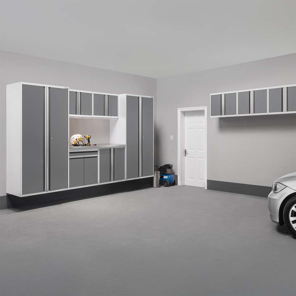 Modern Garage With Wall Mounted Gray And White Cabinets A Workstation And A Parked Silver Car
