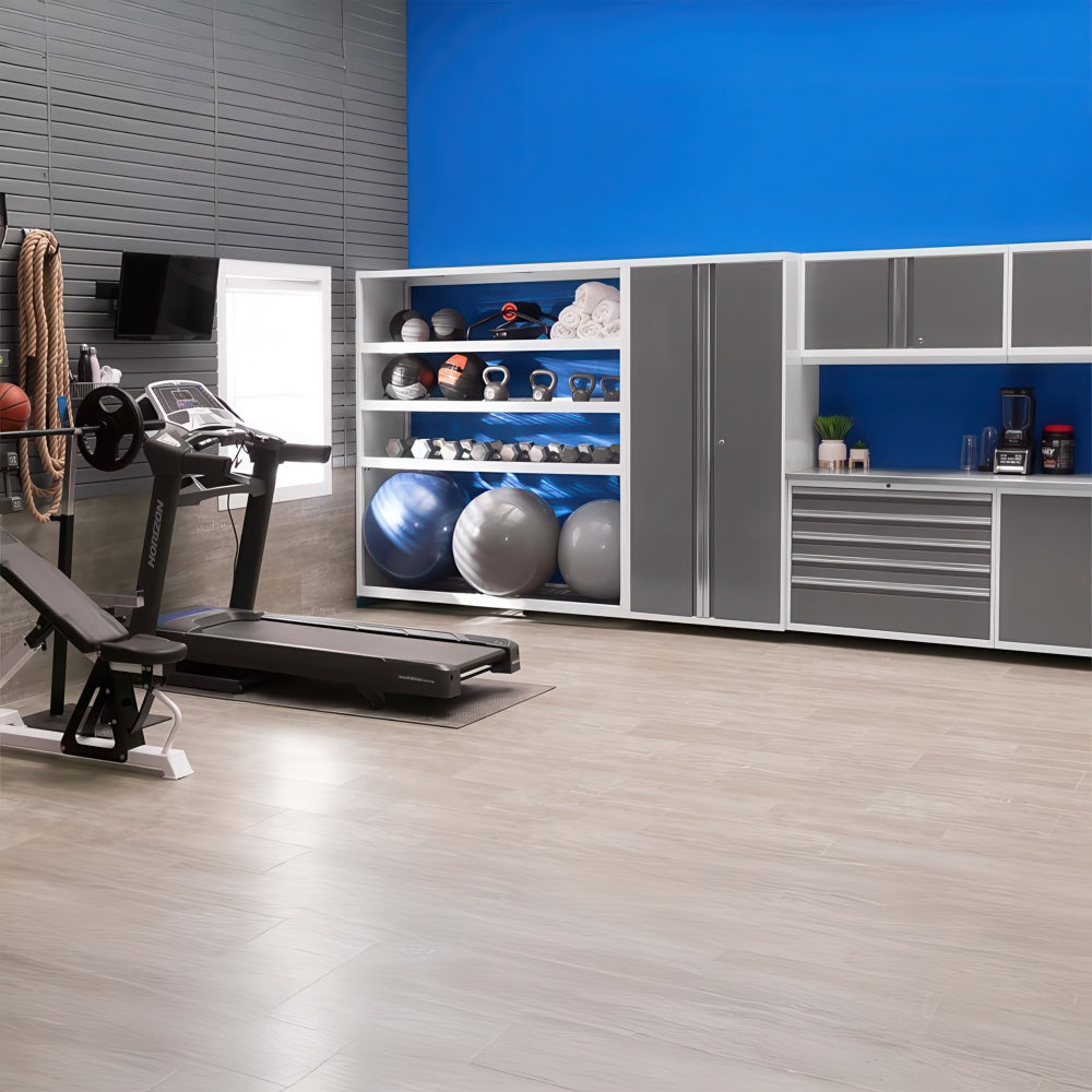 Modern Home Gym With White And Gray Storage Cabinets Open Shelves Of Exercise Balls And Kettlebells And Cardio Equipment Against A Bright Blue Accent Wall