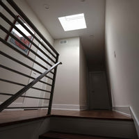 Modern Staircase Hallway With Wooden Flooring And Ceiling Skylight