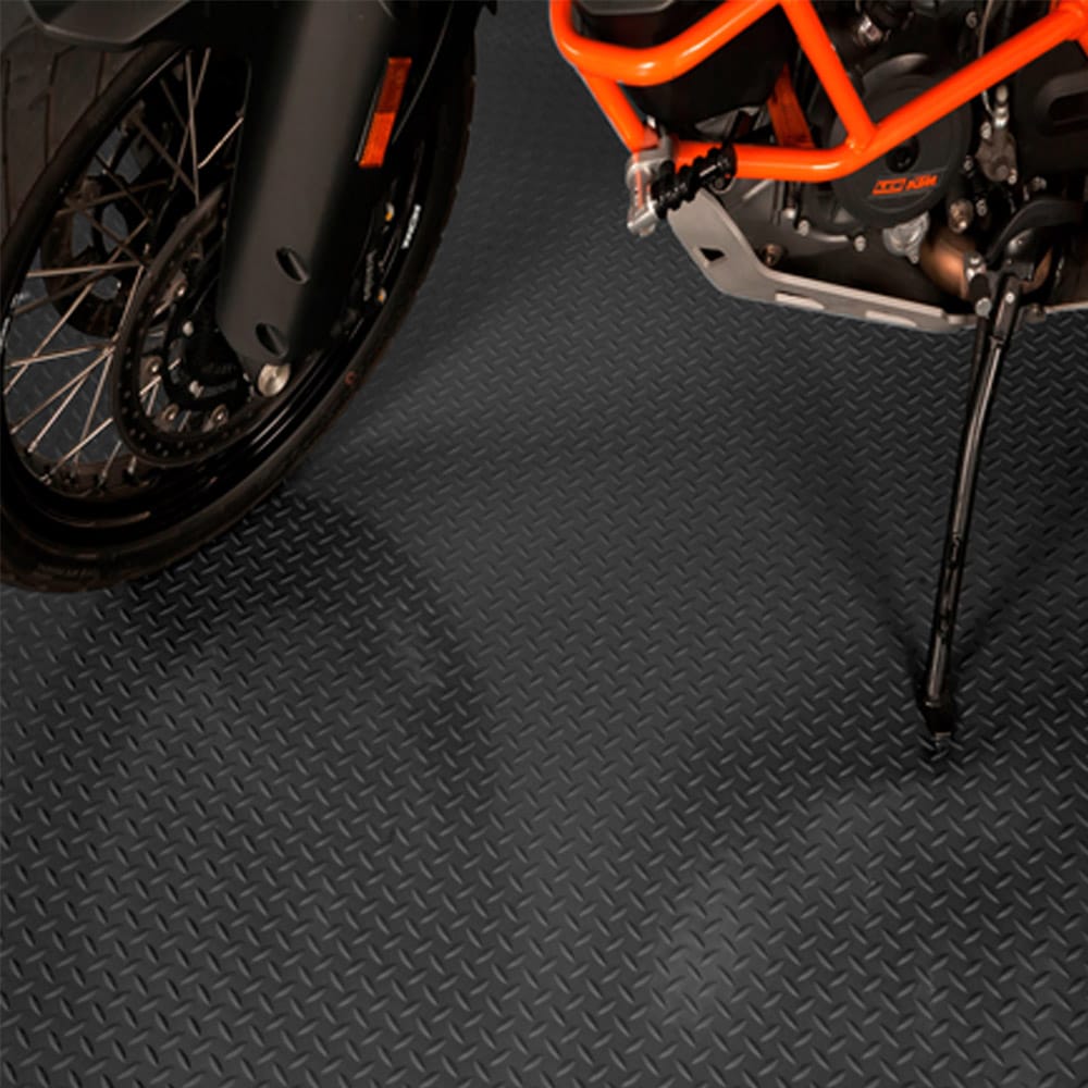 Motorcycle With Orange And Black Accents Parked On A Black Diamond Patterned G-Flooring
