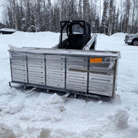 Multi Drawer Cabinet Sits On A Pallet In Deep Snow In Front Of A Skid Steer