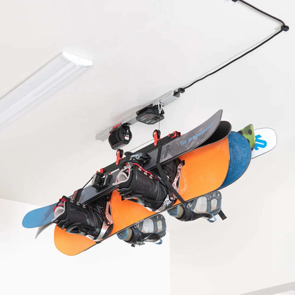 Multiple Snowboards Mounted On A Garage Lifter By SmarterHome Attached To The Ceiling