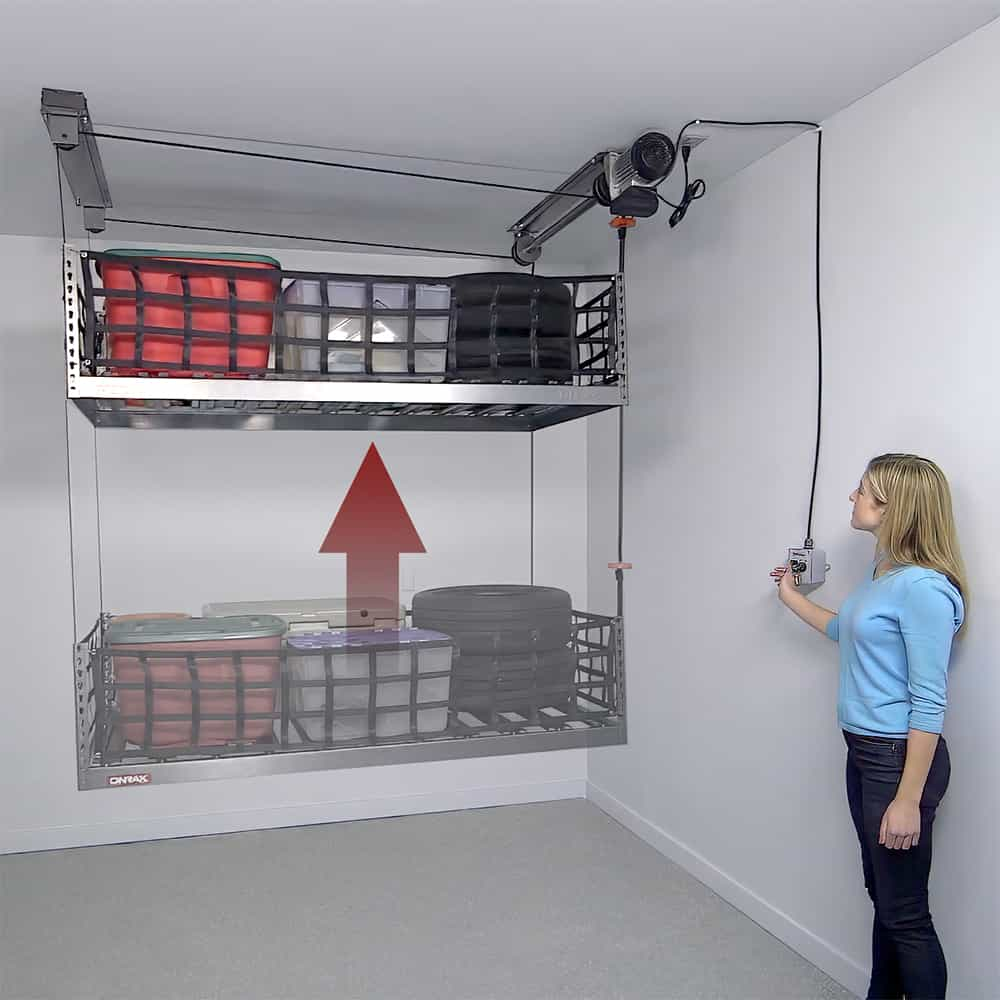 Woman operating ONRAX motorized garage storage lift system with key lock control, lifting platform loaded with storage bins